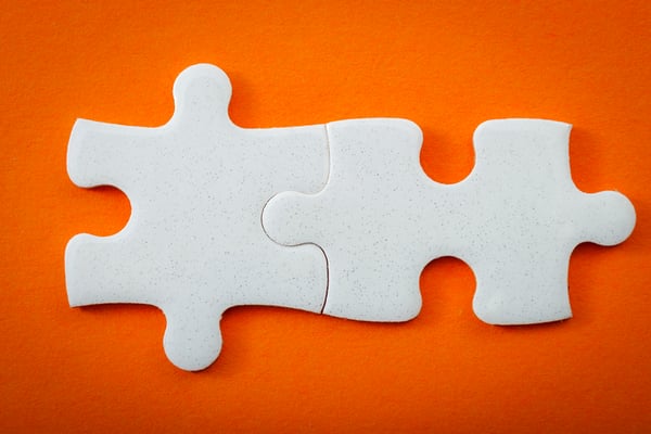 Two puzzle pieces show putting together a strategy